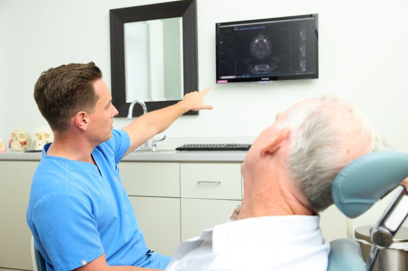 Oral Surgeon Dr. Daniel Hyneman discussing details with a patient